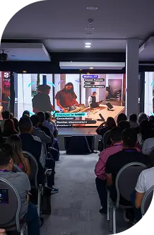 Asistentes a un evento observan una presentación en pantallas, destacando el tema de la línea de tiempo 2024.
